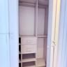 Custom storage system featuring two stacked drawers, open shelving, and integrated hanging rods with metal hardware