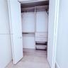 Closet featuring bi-fold doors, integrated shelving, two storage drawers with metallic hardware, and a metal hanging rod