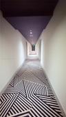 Hallway featuring geometric patterned carpeting, a deep-toned ceiling, and recessed lighting