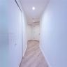 Hallway featuring wood-finish flooring, recessed lighting, and multiple interior closet doors with white hardware