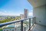 Covered balcony featuring wood-finish flooring and a glass railing with a dark metal frame