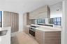 Modern kitchen featuring flat-panel wood-finish cabinetry, white solid-surface countertops, a mirrored backsplash, stainless steel built-in oven with 