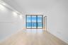 Interior space featuring light-toned wood-finish flooring, recessed ceiling lighting, and floor-to-ceiling glass sliding doors opening to an exterior 