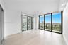 Floor-to-ceiling windows, wood-finish flooring, recessed lighting, and a private balcony with metal railings
