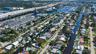 Aerial perspective of the waterfront residential property featuring direct canal access, a private dock, and mature landscaping
