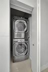 Closet housing a stackable stainless steel washer and dryer unit