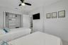Bedroom featuring high ceilings, a ceiling fan with integrated lighting, and a reach-in closet with built-in shelving