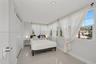 Bright interior space featuring polished tile flooring, recessed lighting, and multiple windows with muntin detailing