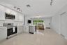 Kitchen featuring white cabinetry, stainless steel appliances, stone-finish countertops, tile flooring, and track lighting