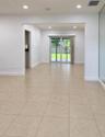 Neutral ceramic tile flooring, recessed lighting, and sliding glass doors leading to a paved patio
