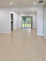 Neutral ceramic tile flooring, recessed lighting, and sliding glass doors leading to a rear exterior space