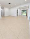 Neutral-toned large-format tile flooring, recessed ceiling lighting, and sliding glass door leading to an outdoor space