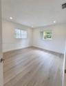 Interior space featuring wood-finish flooring, recessed lighting, and dual windows with vertical blinds