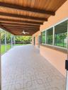 Screened lanai featuring a wood-beam ceiling, patterned tile flooring, an integrated serving bar, and a ceiling fan