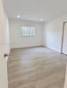 Interior space featuring wood-finish flooring, neutral walls, recessed lighting, vertical window blinds, and a built-in closet