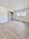 Neutral-toned wood-finish flooring, recessed lighting, and a closet with louvered bi-fold doors