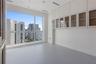 Floor-to-ceiling windows, extensive wall-to-wall built-in cabinetry featuring glass-front upper storage, and smooth-finish flooring