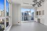 Floor-to-ceiling windows, built-in cabinetry with glass-front uppers, integrated desk surface, ceiling-mounted adjustable lighting fixtures, and solid