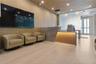 Reception area featuring ribbed wood wall paneling, a stone-faced built-in reception desk with integrated lighting, recessed ceiling lighting, and lar