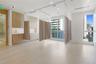 Custom light-finish cabinetry with integrated sink, porcelain tile flooring, ceiling-mounted track systems, recessed lighting, and large windows