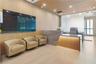 Reception area featuring vertical wood-slat wall paneling, stone-front desk with integrated lighting, wood-finish ceiling, and recessed lighting