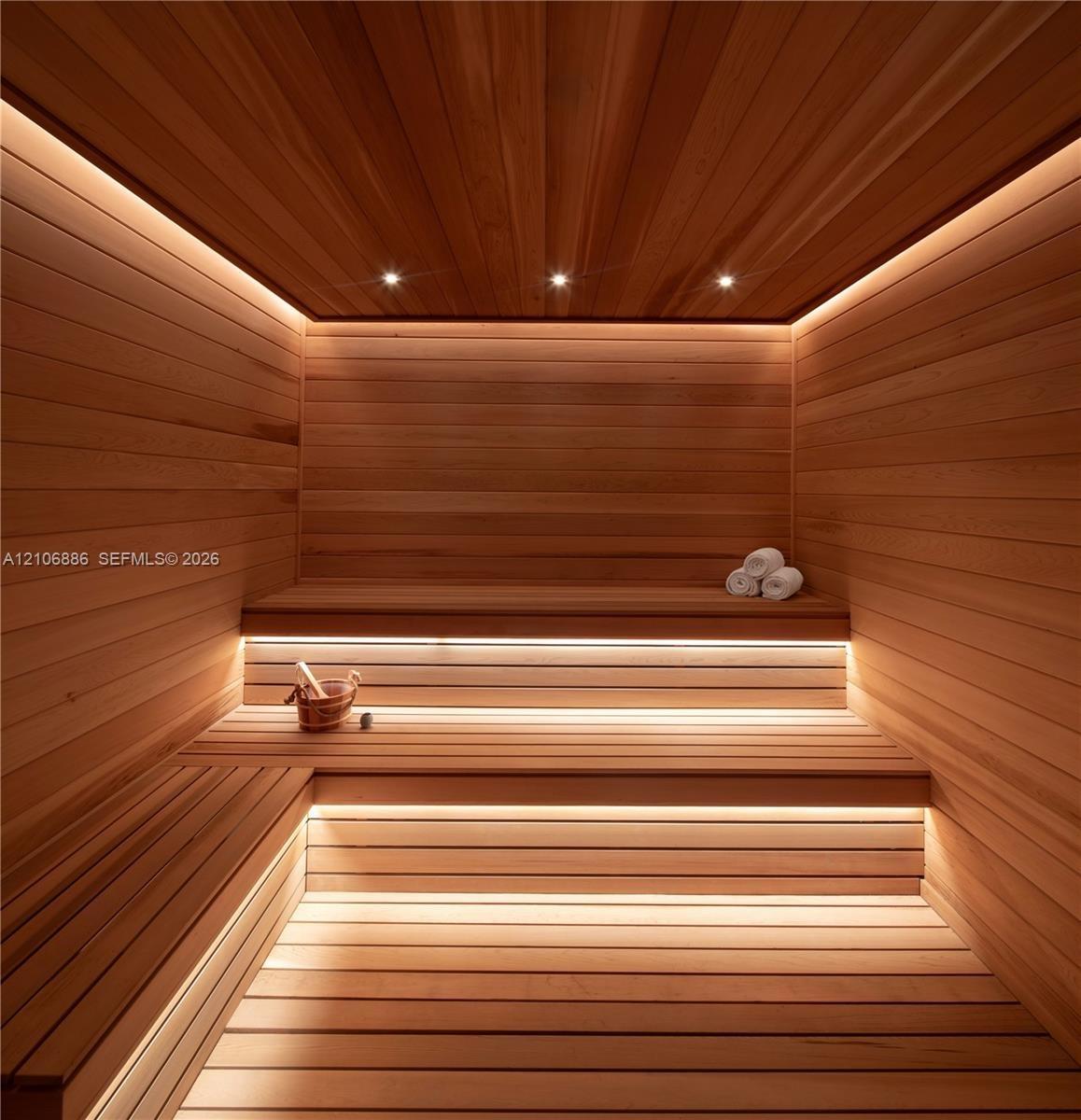 Custom-built sauna featuring tongue-and-groove wood paneling, multi-level tiered benches, recessed ceiling lighting, and integrated linear LED accent 