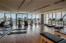 Fitness center featuring floor-to-ceiling windows, wood-finish flooring, recessed track lighting, and a full-length wall mirror