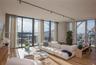 Floor-to-ceiling glass windows, wide-plank wood-finish flooring, exposed concrete structural pillar, and track lighting