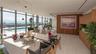 Floor-to-ceiling glass walls, integrated outdoor swimming pool, wood-paneled feature wall, and custom built-in cabinetry