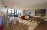 Open-concept living space featuring wood-finish flooring, floor-to-ceiling windows, recessed lighting, and a modern multi-arm pendant light fixture