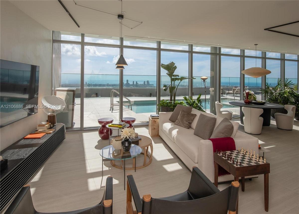Floor-to-ceiling glass walls, expansive terrace, private swimming pool, neutral stone-finish tile flooring, and integrated ceiling lighting
