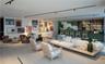 Open floor plan featuring wood-finish flooring, built-in wet bar with glass shelving, and track lighting system