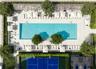 Rectangular swimming pool with tiled surround, pickleball court with hard surface, and perimeter landscaping
