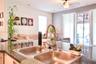 Kitchen island featuring a stone countertop, dual-basin stainless steel undermount sink, and a high-arch pull-down faucet