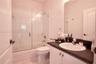 Bathroom featuring a vanity with a dark countertop and integrated sink, a glass-enclosed shower and tub combination, and wall-to-wall mirror