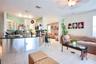 Kitchen featuring a curved peninsula with metallic base cabinetry, dark stone-finish countertops, tile flooring, glass-front upper cabinets, and reces