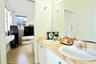 Dual-basin vanity featuring stone-finish countertops, undermount sinks, polished metal faucets, and a large wall-mounted mirror
