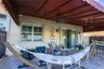 Covered paver patio featuring a retractable awning, dual ceiling fans, wall-mounted light fixtures, and glass sliding doors