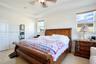 Tray ceiling, multi-pane windows, and neutral interior wall finish, complemented by hard-surface flooring and an overhead ceiling fan fixture
