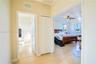 Hallway featuring wood-finish flooring, two sets of white paneled doors, and one white bi-fold closet door