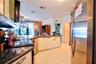 Kitchen featuring stainless steel appliances, dark stone-finish countertops, white cabinetry with metal hardware, and tiled flooring