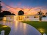 Single-story exterior featuring a stamped concrete driveway, exterior landscape lighting, and a fenced perimeter