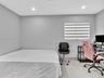 Room featuring neutral-toned walls, recessed lighting, and a window equipped with banded roller shades