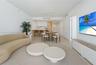 Open-concept interior featuring wood-finish flooring, recessed lighting, and a kitchen equipped with white cabinetry and a breakfast bar