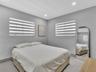 Neutral wall tones featuring dual-tone striped window shades and recessed ceiling lighting throughout