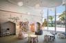 Floor-to-ceiling windows, custom built-in alcoves, patterned wall covering, recessed ceiling lighting with cloud-shaped pendants, and expansive carpet