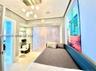 Recessed ceiling lighting, multi-globe pendant light fixture, built-in glass shelving, light-toned stone-finish flooring, and integrated wall paneling