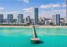 Aerial perspective of Atlantic coastline featuring turquoise ocean waters and a prominent concrete fishing pier