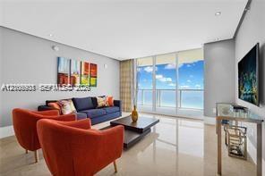 Floor-to-ceiling glass windows, polished tile flooring, recessed ceiling lighting, and neutral wall tones