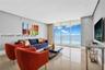 Floor-to-ceiling glass windows, polished tile flooring, recessed ceiling lighting, and neutral wall tones
